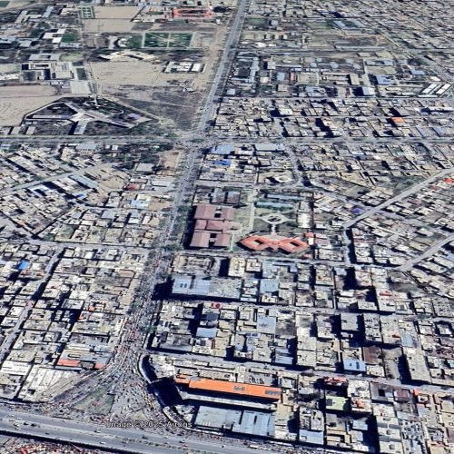 44 Aerial view of a dense urban area featuring interconnected road networks and buildings in Kabul. The image highlights the organized urban layout with notable structures and open spaces in the background.