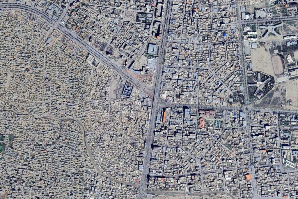 Aerial view of Kabul, Afghanistan, displaying a juxtaposition of planned formal urban grids with chaotic informal settlement areas, emphasizing the city's diverse urban fabric.
