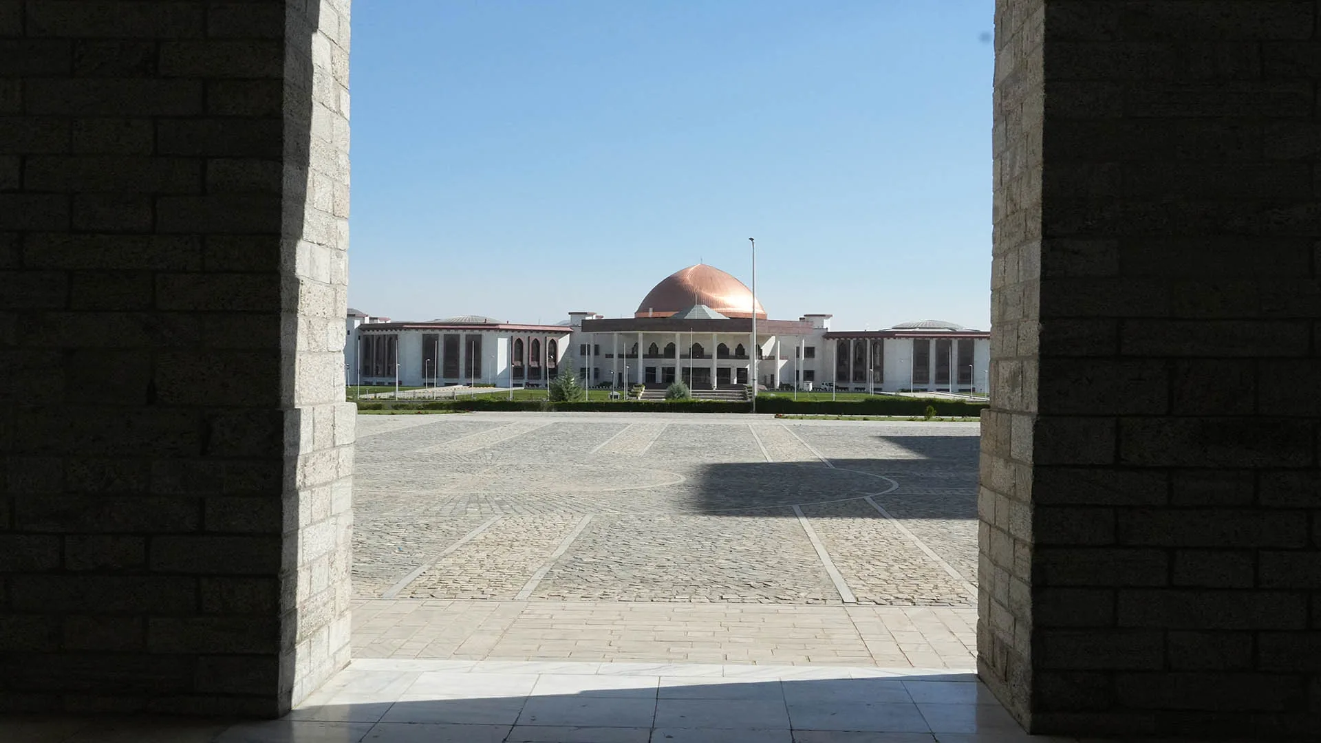 A view of Afghanistan’s Wolesi Jirga building framed by stone archways.