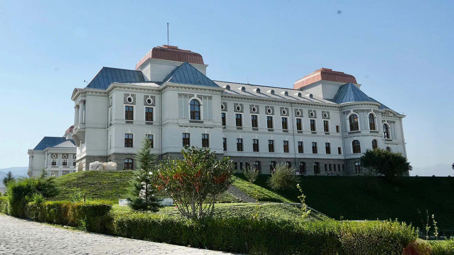 Darulaman Palace in Kabul, Afghanistan, a historic neoclassical landmark surrounded by greenery and clear skies