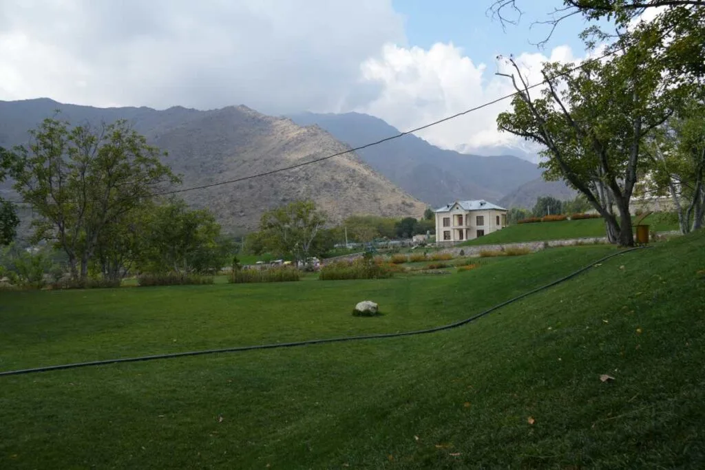Scenic view of Bala Bagh Palace surrounded by greenery and majestic mountain ranges