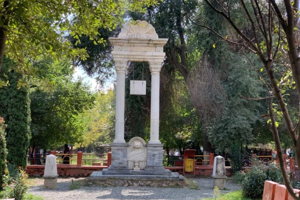 An independence memorial in Paghman with classical columns, a decorative pediment, and a central plaque set amidst lush greenery.